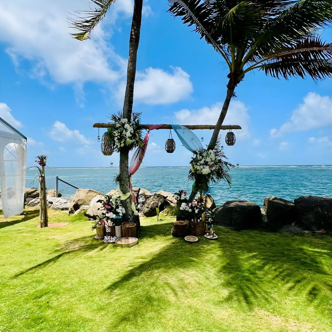 Arche de mariage naturelle entre cocotiers avec bambou et fleurs tropicales en Martinique