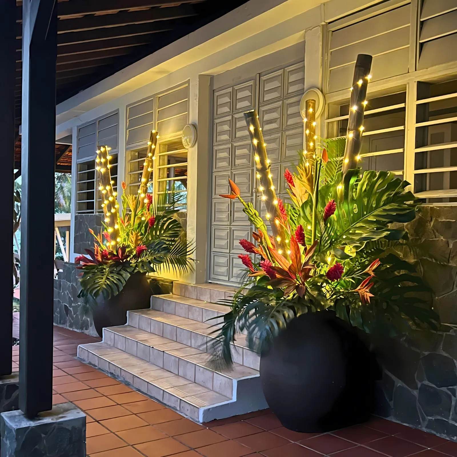 Composition tropicale dans jarre avec fleurs et feuillages pour décoration de mariage en Martinique