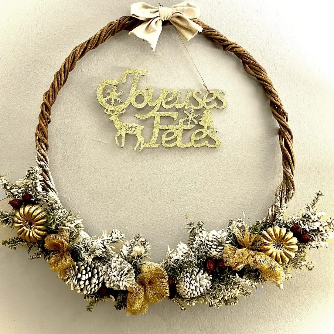 Couronne de Noël artisanale en lianes avec décoration naturelle blanc or et message Joyeuses Fêtes pour hôtel en Martinique