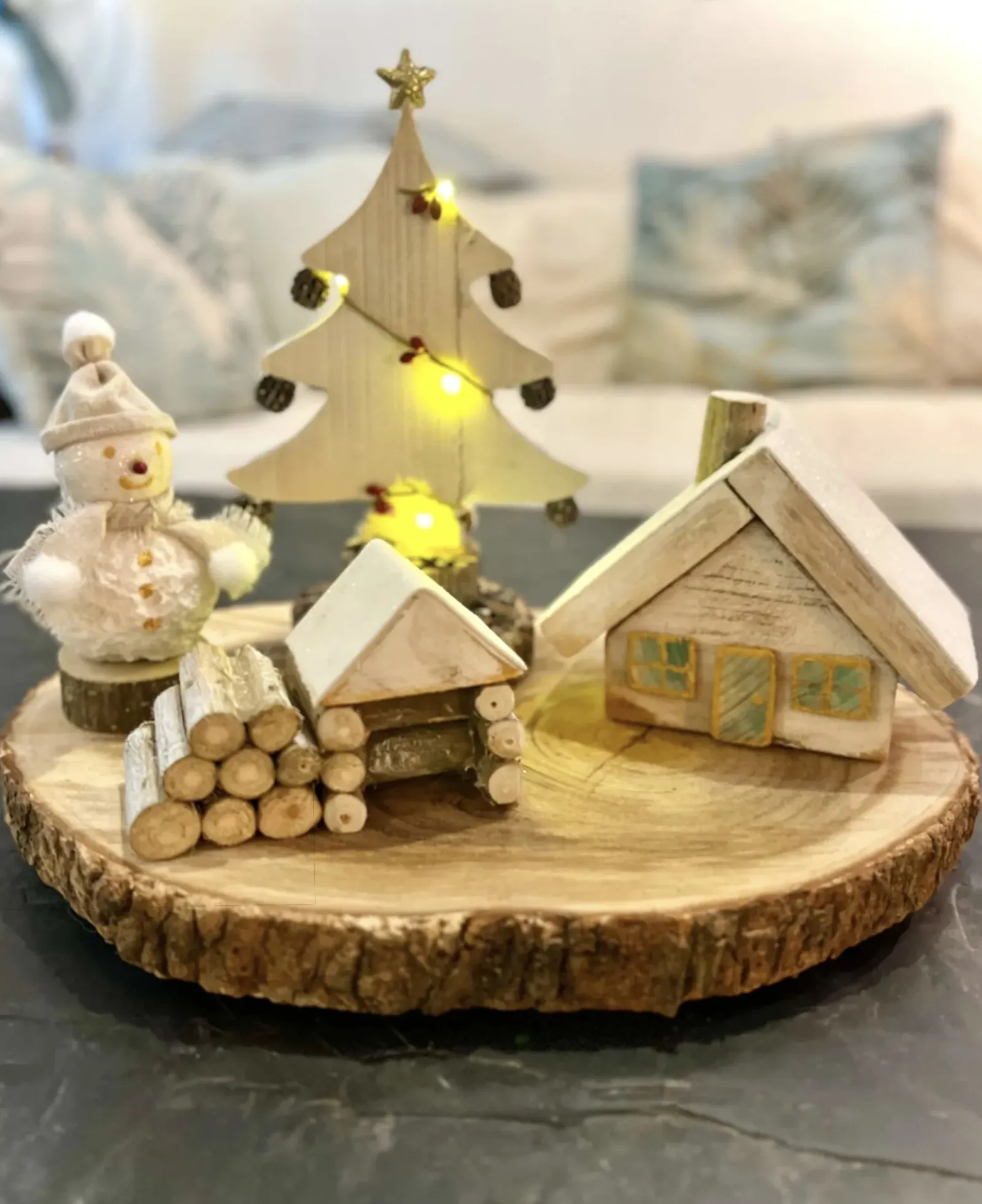 Décoration de Noël artisanale sur rondin de zamana avec chalet miniature, sapin lumineux et éléments en bois recyclé en Martinique