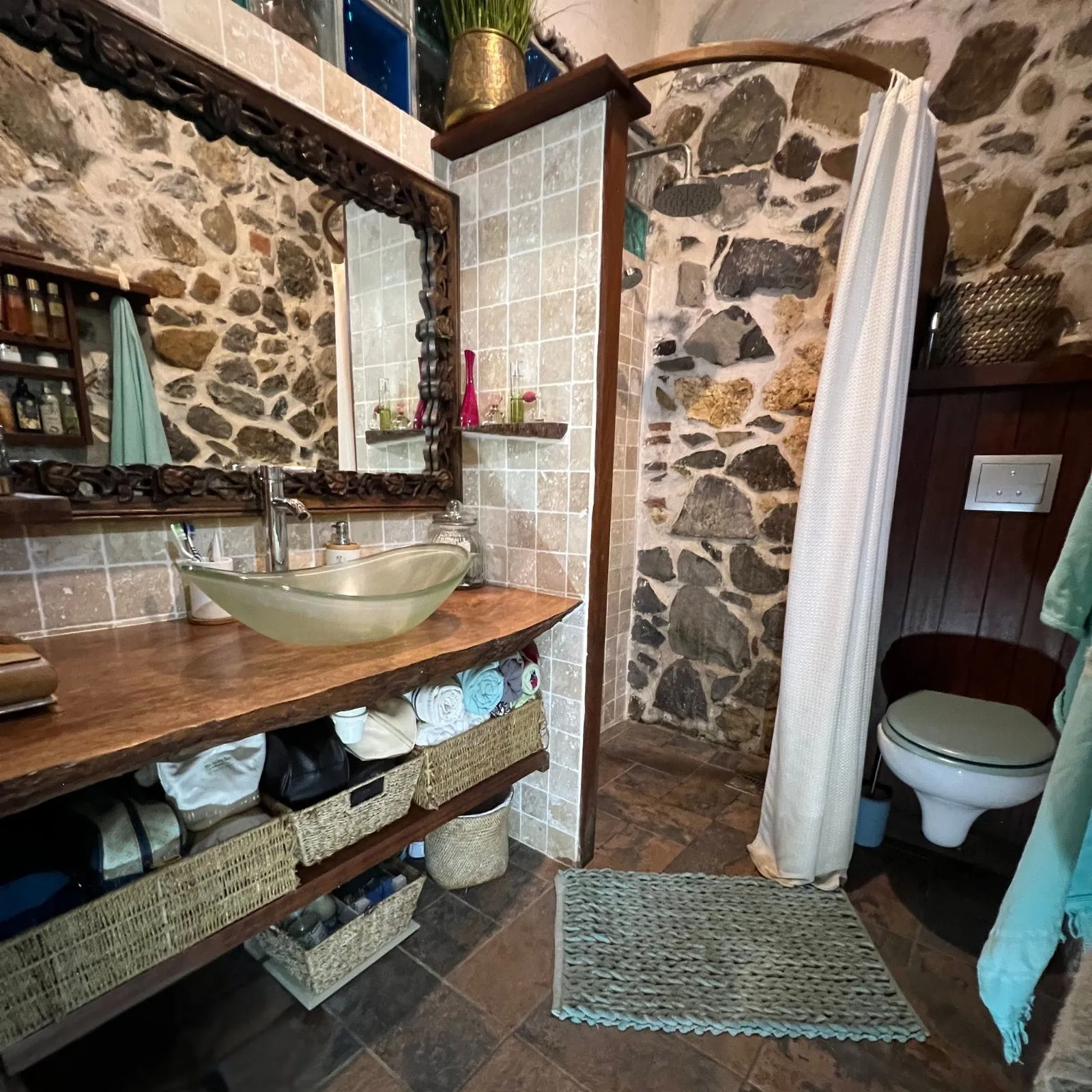 Avant après rénovation salle de bain en Martinique avec murs en pierre apparente et aménagement optimisé