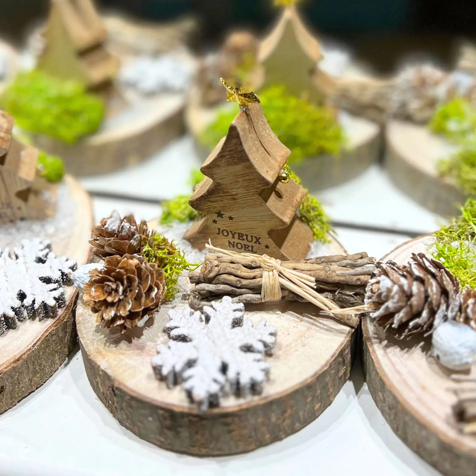 Centres de table de Noël sur rondins de bois avec sapin, pommes de pin et décoration naturelle en Martinique