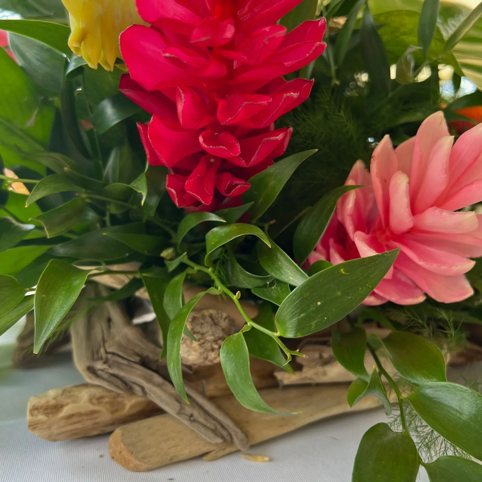 Centres de table en bois flotté avec composition florale tropicale pour mariage en Martinique