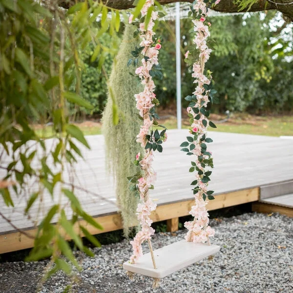 Balançoire suspendue en bois utilisée comme coin photo ou élément de décoration lors d'un mariage ou d'un événement