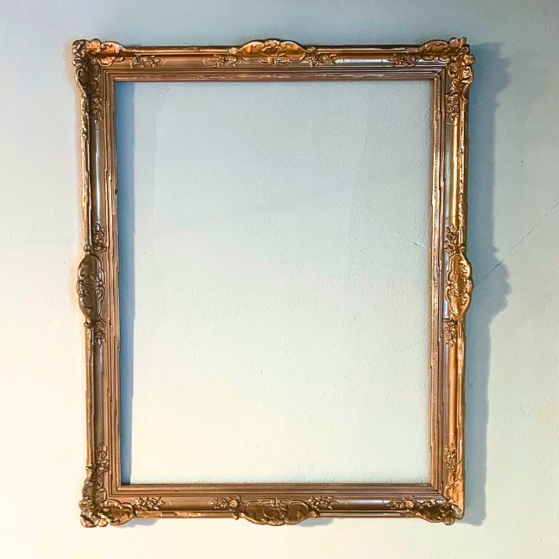 Cadre ancien en plâtre doré de style rocaille utilisé comme support de panneau d'accueil lors d'un mariage