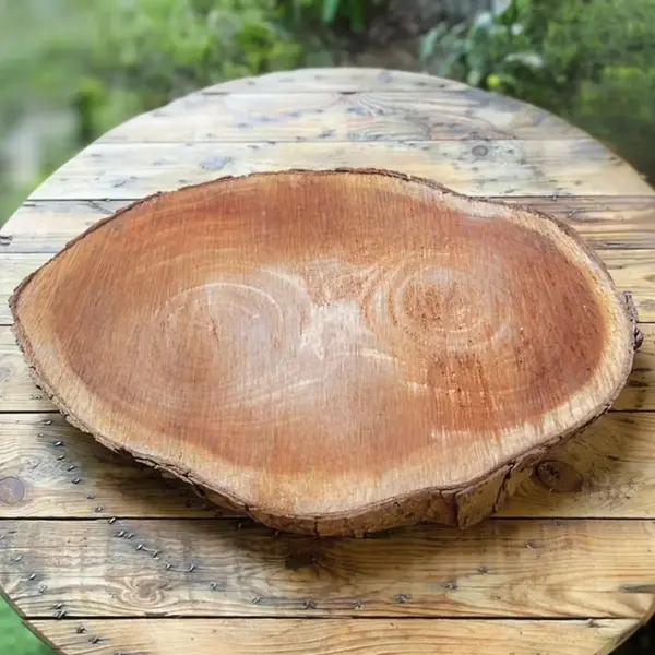 Grand plateau en bois rouge utilisé comme support de décoration ou de présentation lors d'un évènement