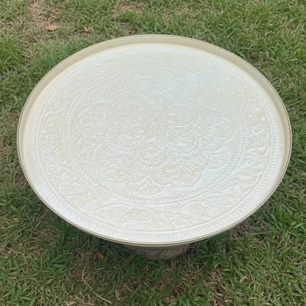 Grand plateau rond émaillé ivoire à bord doré utilisé comme support décoratif ou plateau de présentation lors d'un événement