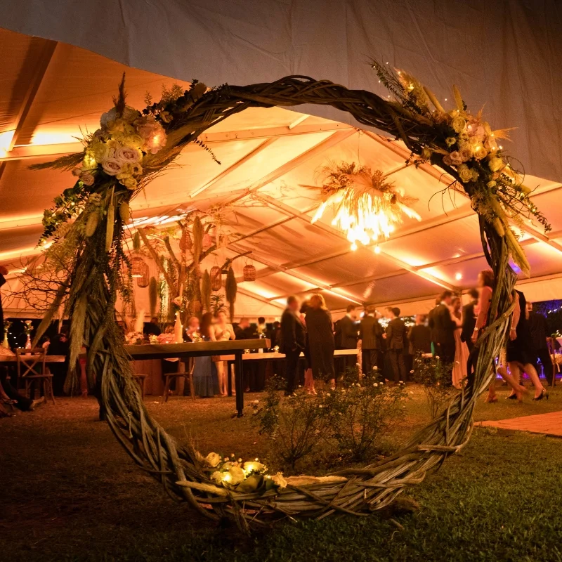 Arche ronde en lianes tressées éclairée pour réception de mariage